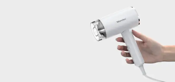 Biała suszarka Warmtec trzymana w dłoni.